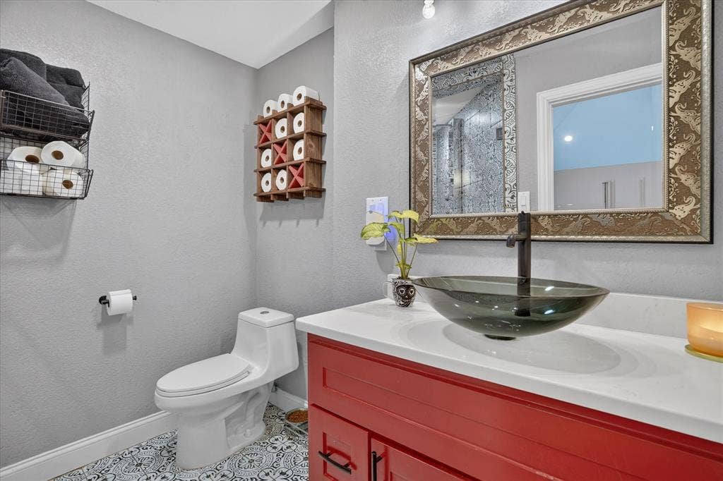 7016 Battle Creek Road, Fort Worth, TX 76116 Vanity with a vessel sink, quartz countertop, and red cabinetry