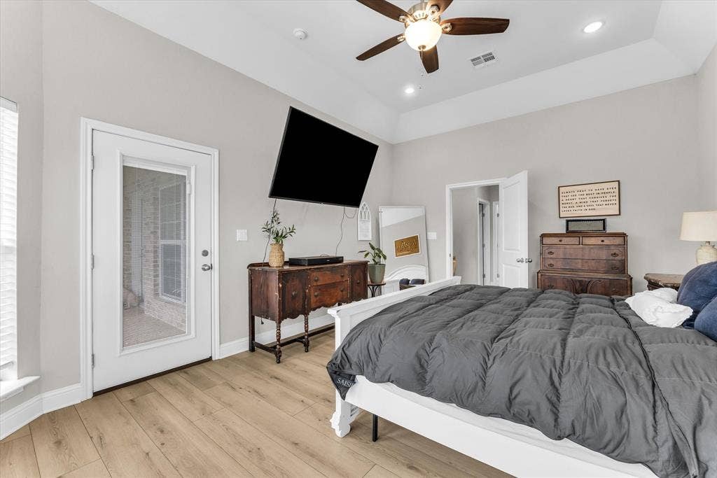 Wood-finish flooring, white trim, a ceiling fan with integrated lighting, recessed lighting, and a full-light exterior door