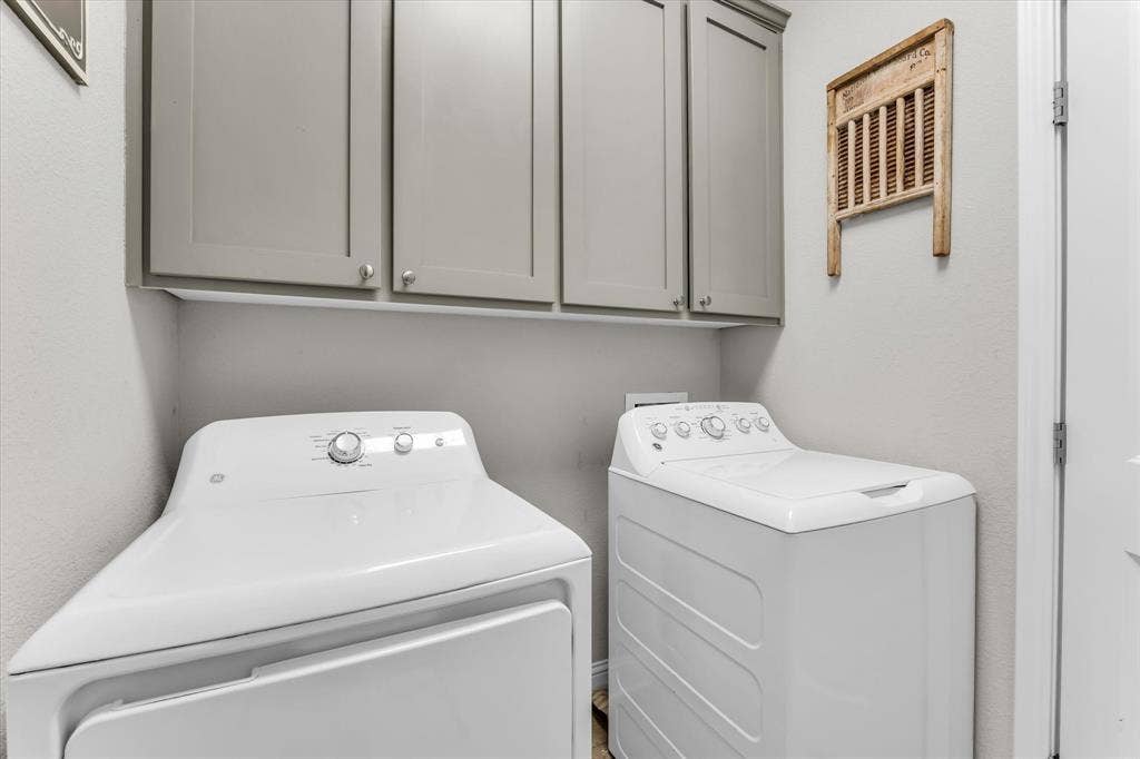 Utility area with upper cabinetry and a light gray finish