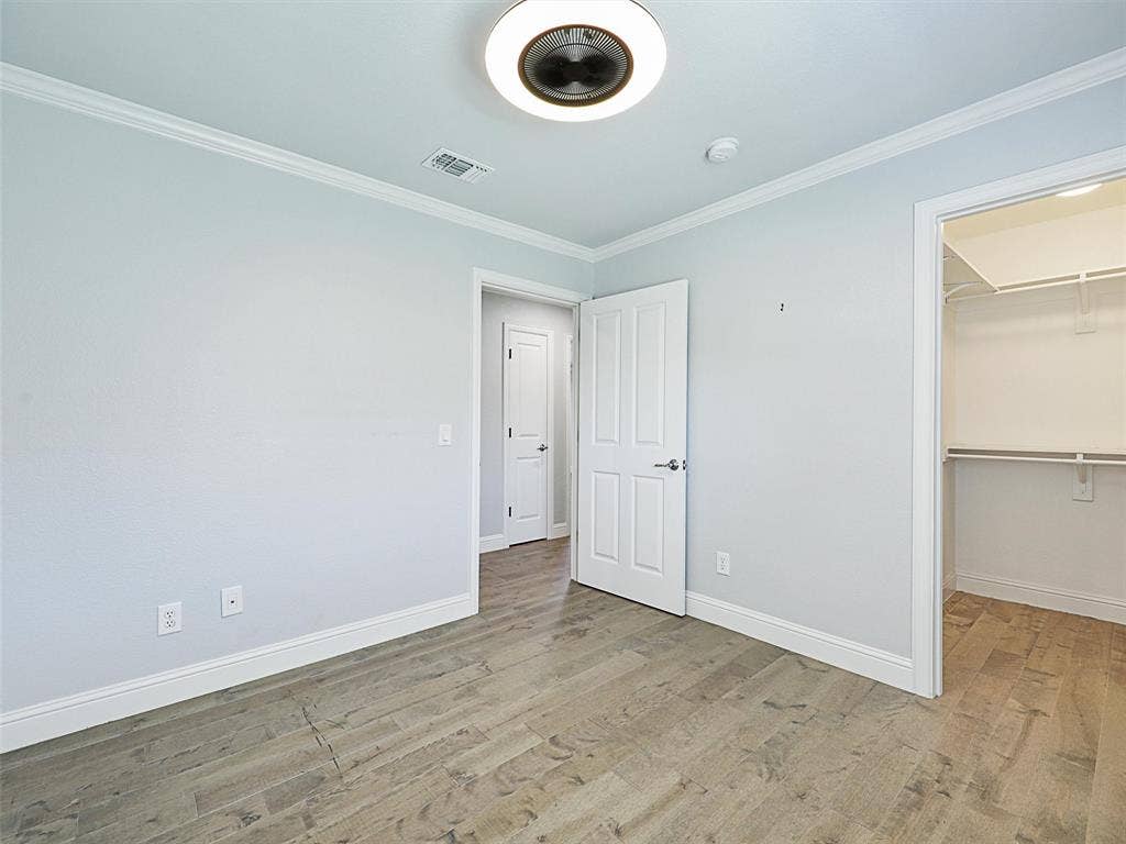 7470 Birmingham Forest Drive, Frisco, TX 75036 Second bedroom featuring crown molding, a walk in closet, and LVP