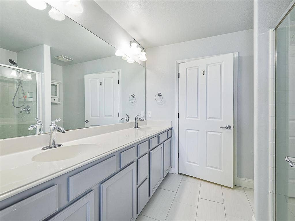 7470 Birmingham Forest Drive, Frisco, TX 75036 Bathroom with tile floors, walk in shower, oversized vanity, and dual sinks