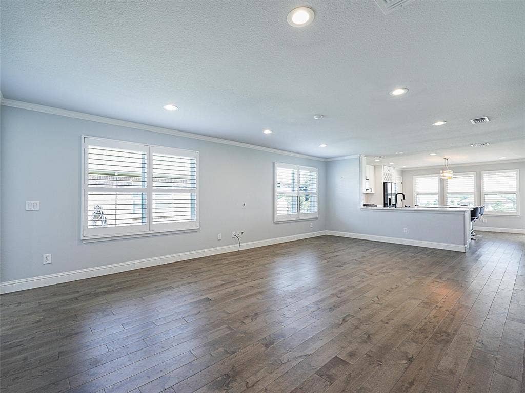 7470 Birmingham Forest Drive, Frisco, TX 75036 Living room with crown molding, neutral paint and LVP.