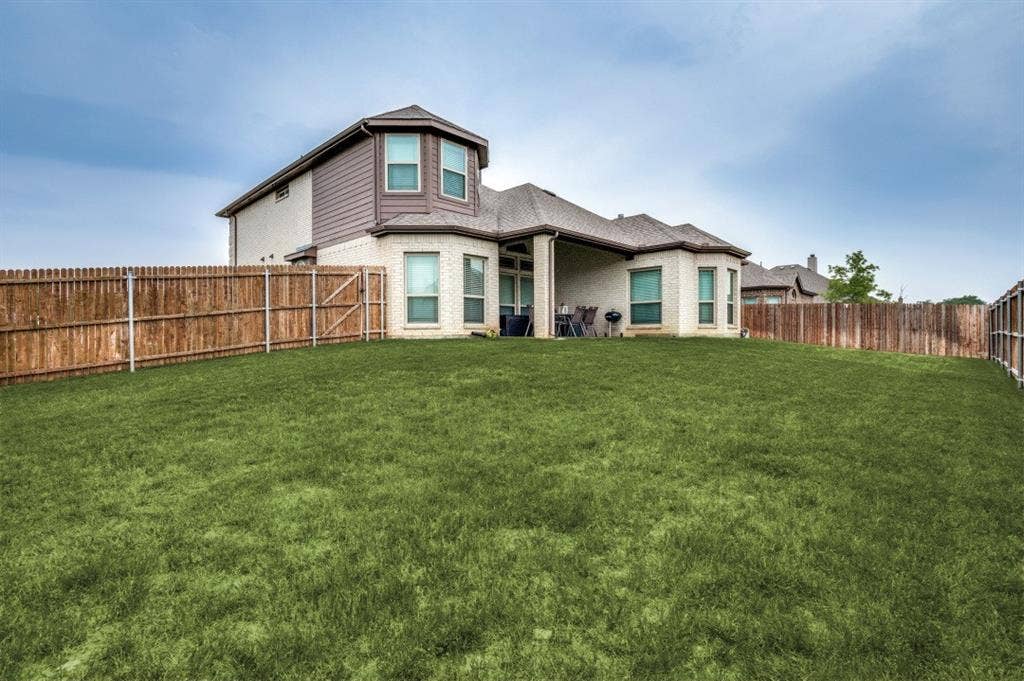 249 Noble Nest Drive, Midlothian, TX 76065 Spacious backyard with a privacy fence, covered patio, and large lawn