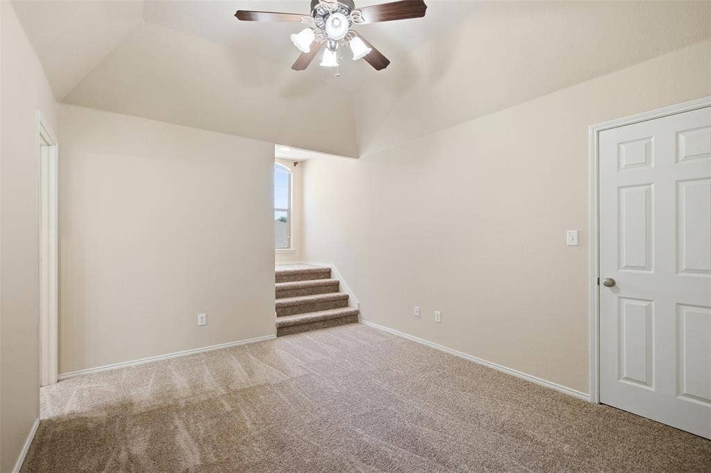 750 Village Green Drive, DeSoto, TX 75115 Vaulted ceiling with a ceiling fan, carpeted flooring, and a paneled interior door