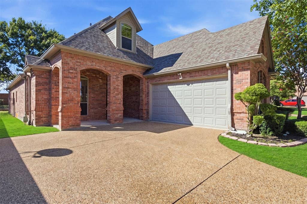 750 Village Green Drive, DeSoto, TX 75115 Red brick exterior with an arched entryway, gabled roof, and attached garage. Green enhancement to lawn.