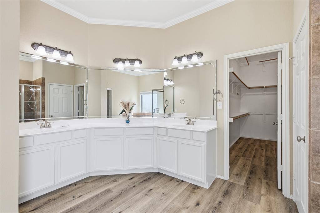 750 Village Green Drive, DeSoto, TX 75115 Dual vanity with white cabinetry, wall-mounted mirrors, and chrome fixtures