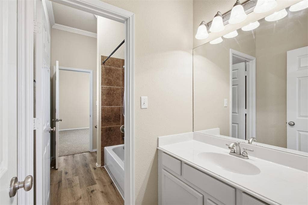 750 Village Green Drive, DeSoto, TX 75115 Vanity with an integrated sink, brushed nickel faucet, large wall mirror, and a five-light fixture