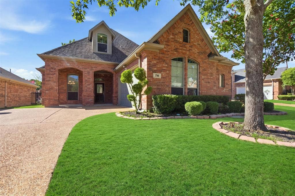 750 Village Green Drive, DeSoto, TX 75115 Brick exterior with arched entryways, dormer window, and a gabled roofline. Green enhancement to lawn.