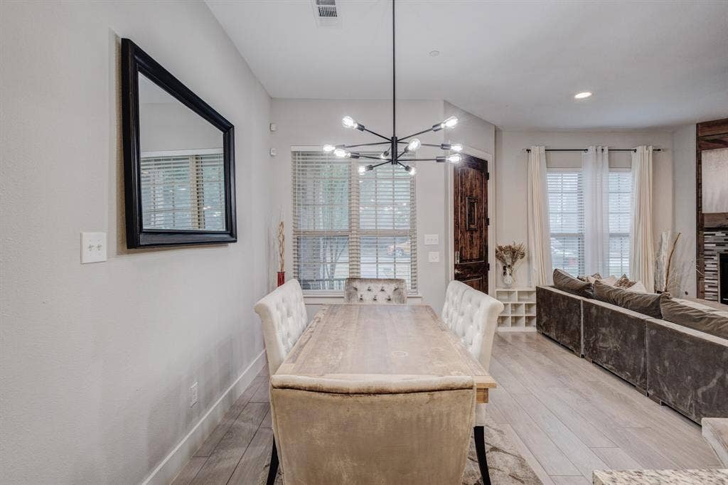 4814 Empire Way, Irving, TX 75038 Open-concept dining area featuring wood-finish flooring, a contemporary chandelier, recessed lighting, and ample natural light from multiple windows