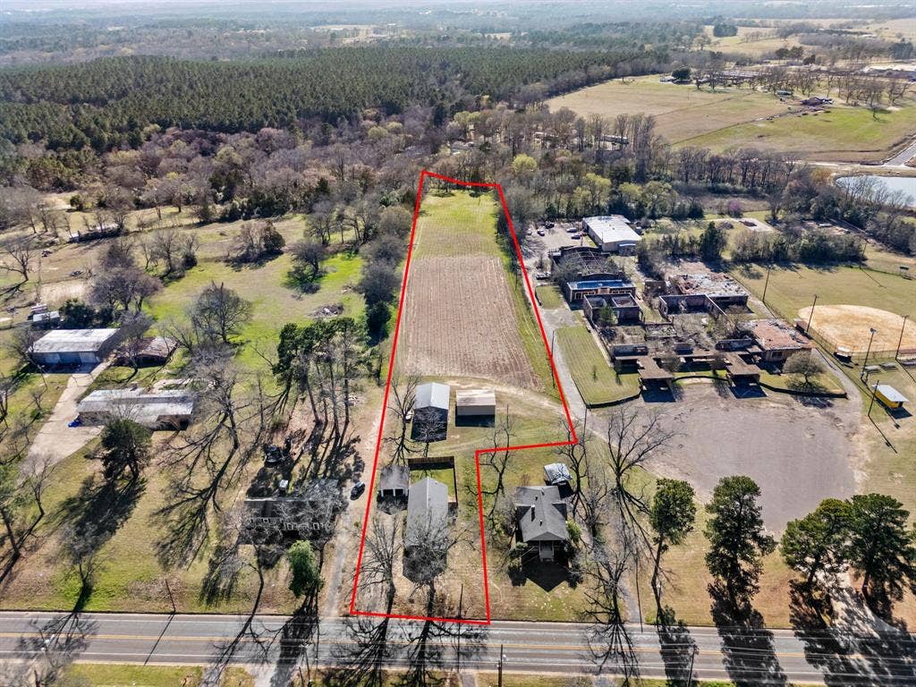 605 Dallas Street, Winona, TX 75792 Expansive property featuring a cultivated field, two residential structures, two outbuildings, and direct road frontage