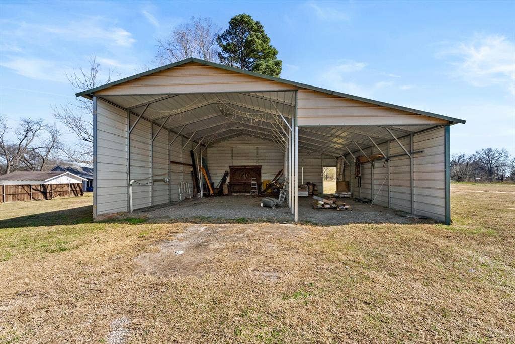 605 Dallas Street, Winona, TX 75792 Metal detached barn structure with a gravel floor and exposed truss ceiling