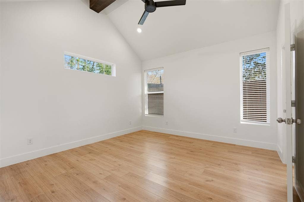 1601 Birdell Street, Fort Worth, TX 76105 Vaulted ceiling with exposed wood beam, wood-finish flooring, multiple windows, and a ceiling fan