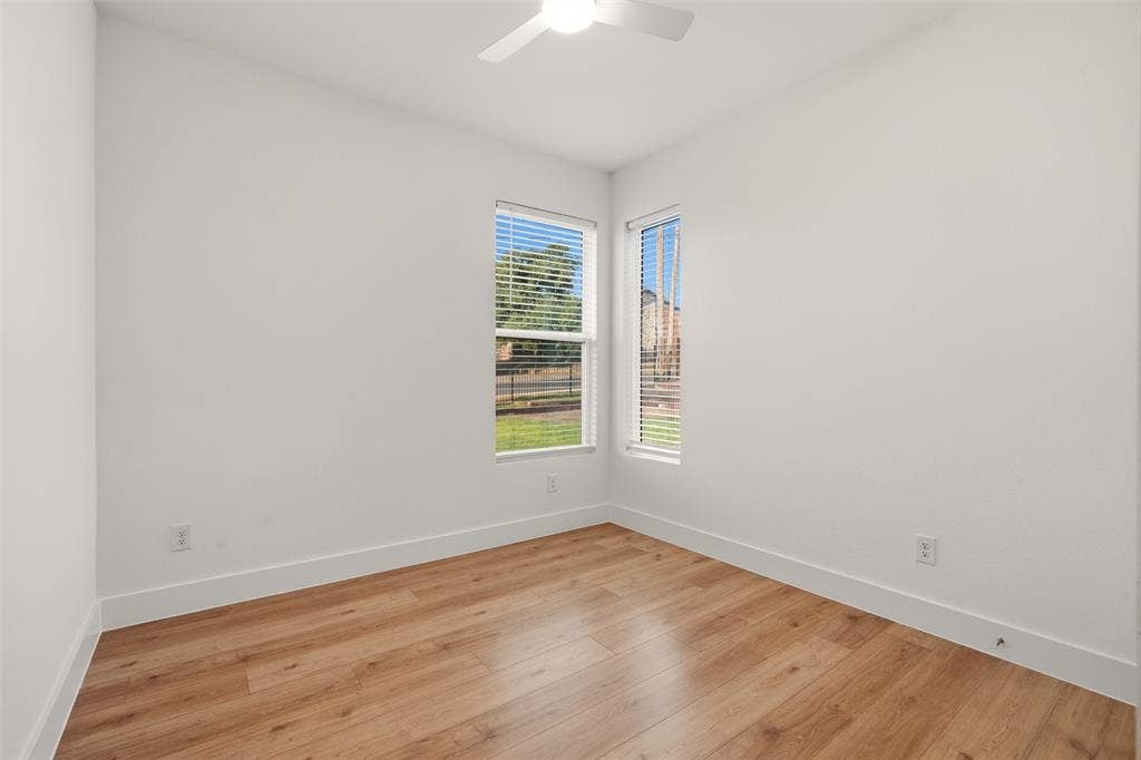 1601 Birdell Street, Fort Worth, TX 76105 Wood-finish flooring, white walls, multiple windows with blinds, and an overhead ceiling fan