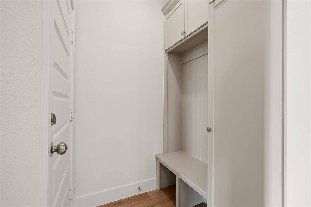 1601 Birdell Street, Fort Worth, TX 76105 Built-in mudroom bench with upper cabinetry, wood-finish flooring, and a white paneled door