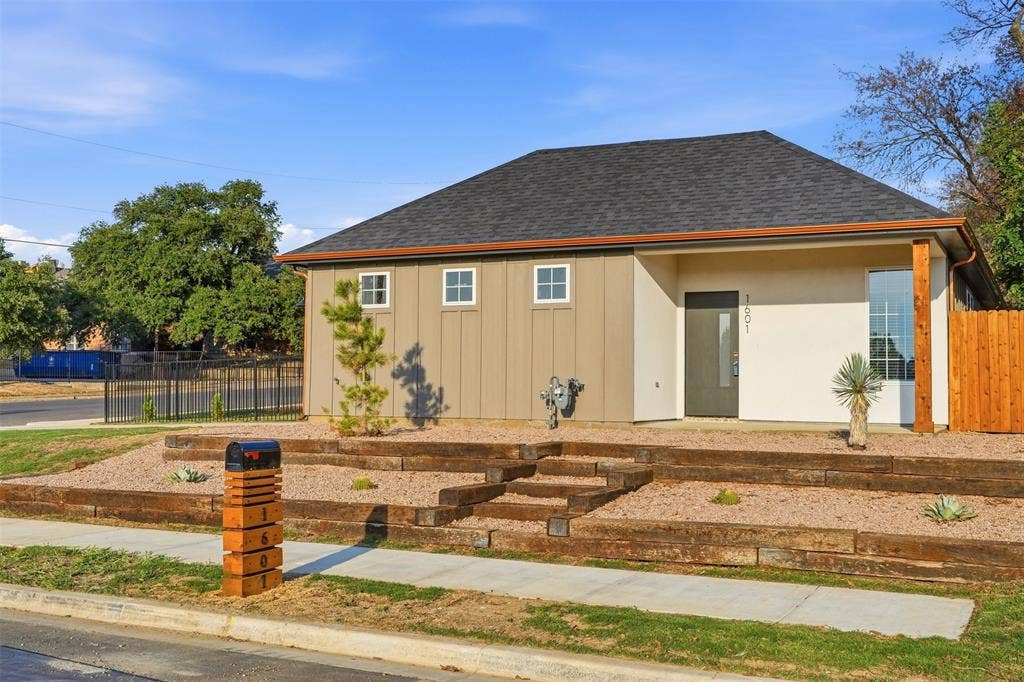 1601 Birdell Street, Fort Worth, TX 76105 Contemporary exterior with board-and-batten siding and stucco, dark shingle roof, and a wood-slat privacy fence