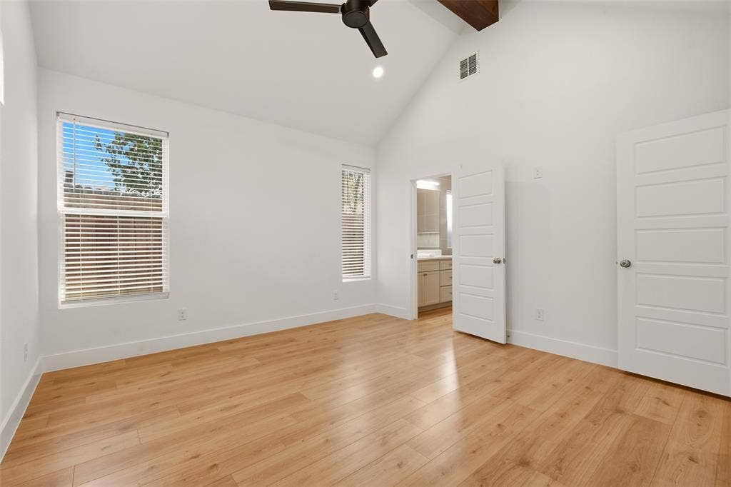 1601 Birdell Street, Fort Worth, TX 76105 Vaulted ceiling with exposed wood beam, wood-finish flooring, two windows with blinds, ceiling fan, and white panel doors