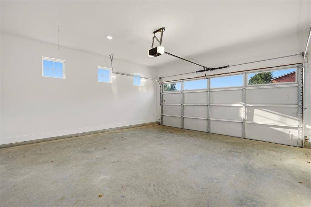 1601 Birdell Street, Fort Worth, TX 76105 Attached two-car garage with a concrete floor, three high-set rectangular windows, and a segmented garage door with upper window panels