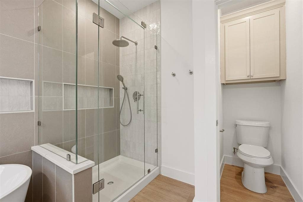 1601 Birdell Street, Fort Worth, TX 76105 Glass-enclosed shower with a rainfall showerhead, handheld sprayer, and integrated wall niches