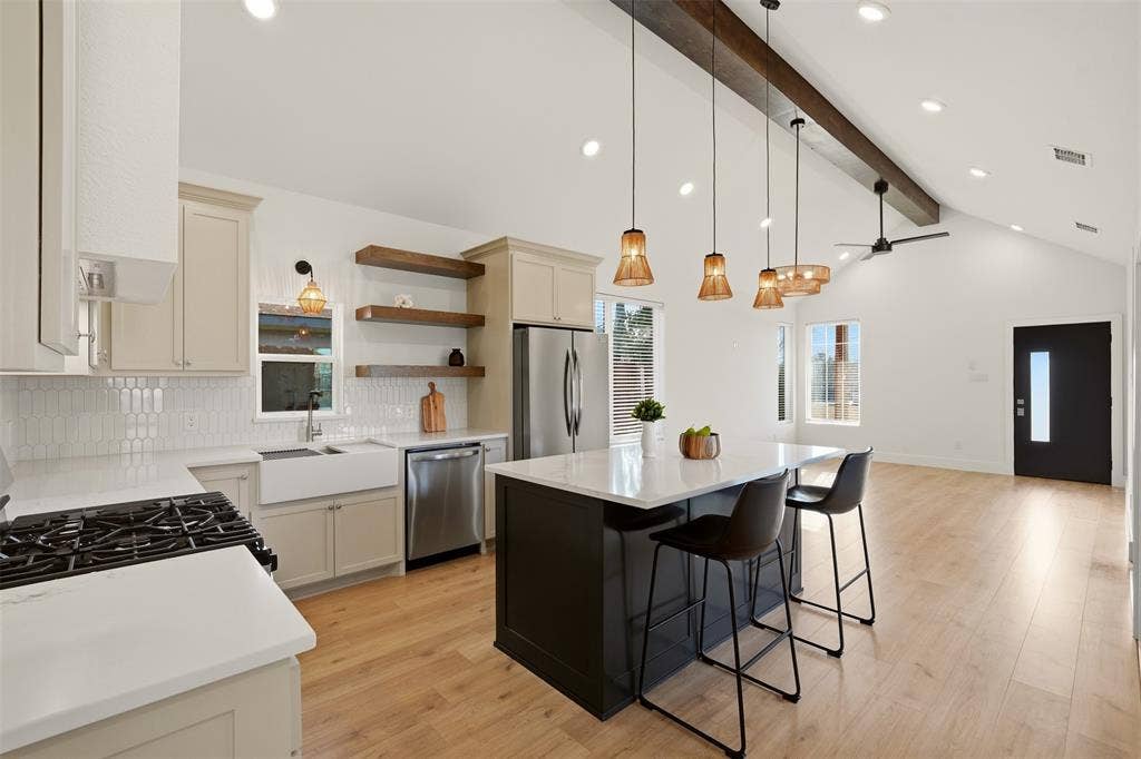 1601 Birdell Street, Fort Worth, TX 76105 Open-concept kitchen with vaulted ceilings, recessed lighting, wood-finish flooring, a kitchen island, and a stainless steel refrigerator