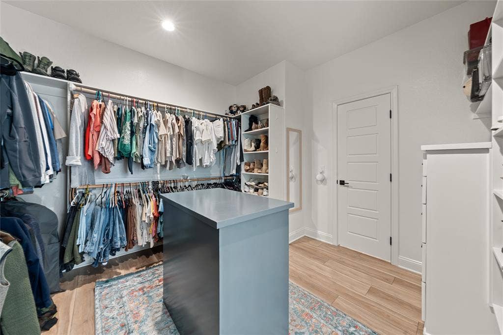 149 Water View Lane, Robinson, TX 76706 Custom closet system featuring a central island, wood-finish flooring, recessed lighting, and white paneled doors
