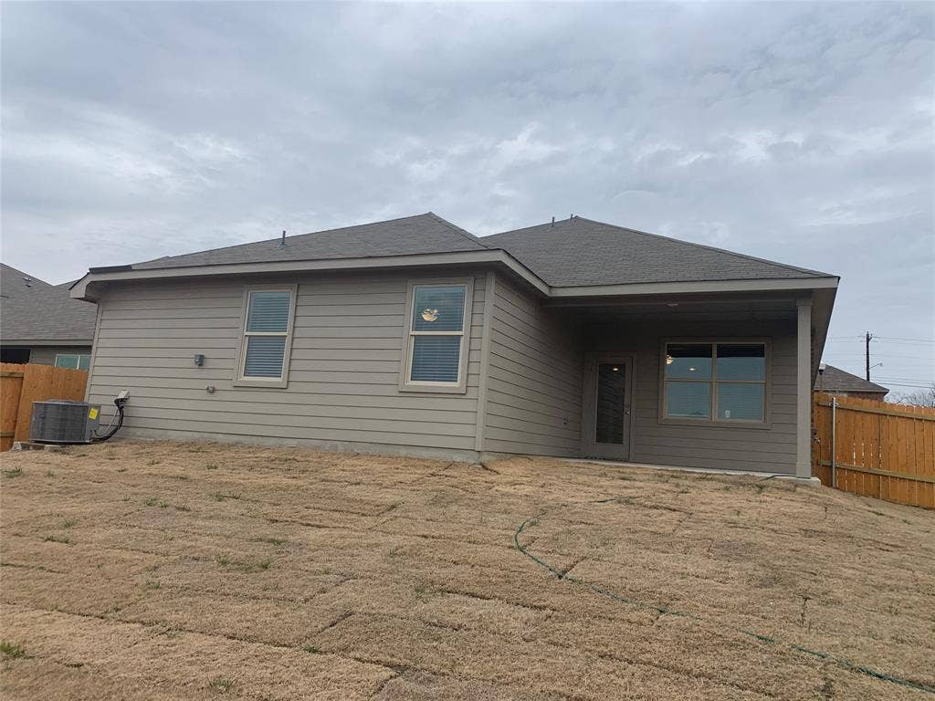 Rear exterior with horizontal siding, a covered patio, and a sloped lawn