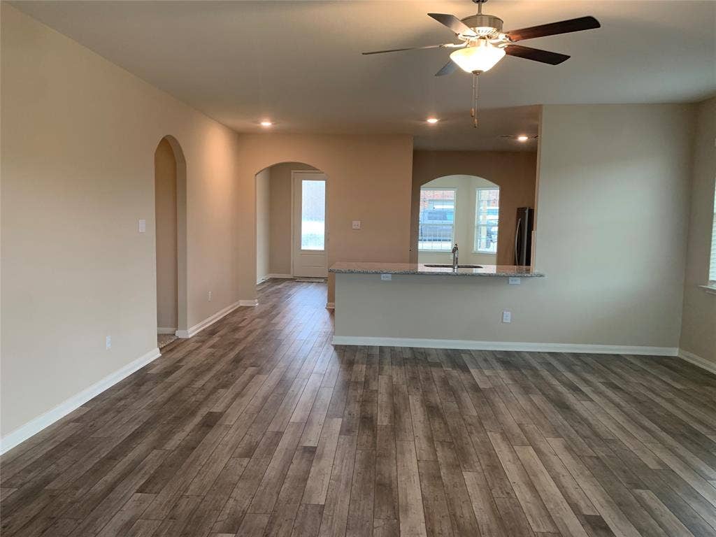 Wood-finish flooring throughout, recessed lighting, and arched doorways