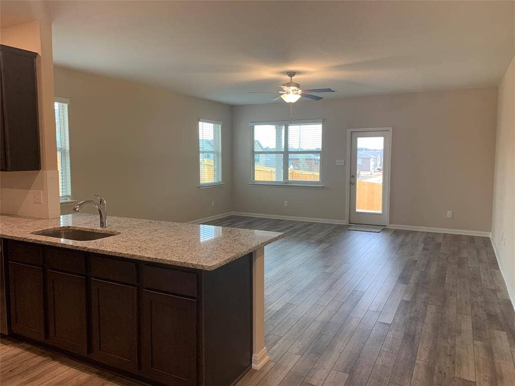 Open-concept living space featuring wood-finish flooring, recessed lighting, and a ceiling fan