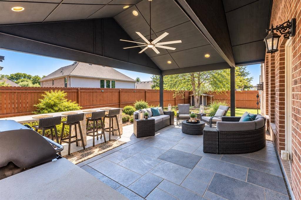 1704 Keswick Drive, McKinney, TX 75071 Covered outdoor patio featuring a ceiling fan with integrated lighting, recessed lighting, and large format stone-finish tile flooring