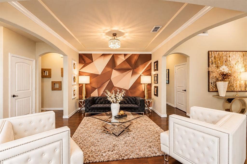 1704 Keswick Drive, McKinney, TX 75071 Elegant formal living area showcasing coffered ceiling detail with recessed lighting, white-painted architectural trim, and dual upholstered seating