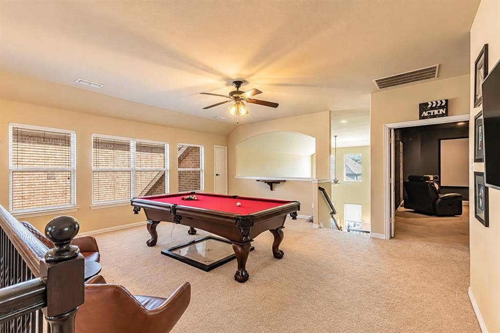1704 Keswick Drive, McKinney, TX 75071 Carpeted recreation area featuring a ceiling fan, multiple windows, and a built-in railing