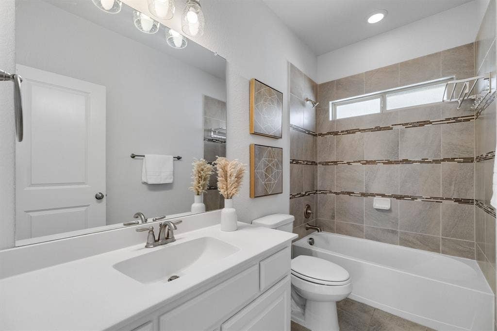 Secondary upstairs bathroom- White vanity with an integrated sink and brushed nickel faucet