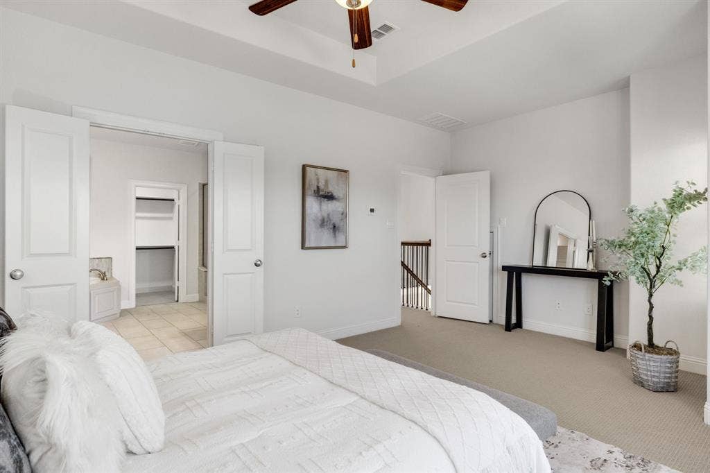 Carpeted room with high ceilings, a ceiling fan, and white interior doors