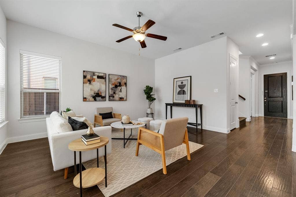 Spacious living area featuring wood-finish flooring, high ceilings, and recessed lighting