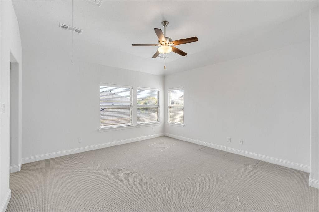 Secondary upstairs bedroom- Recessed lighting with a ceiling fan, multiple windows with blinds, and light-toned carpet flooring