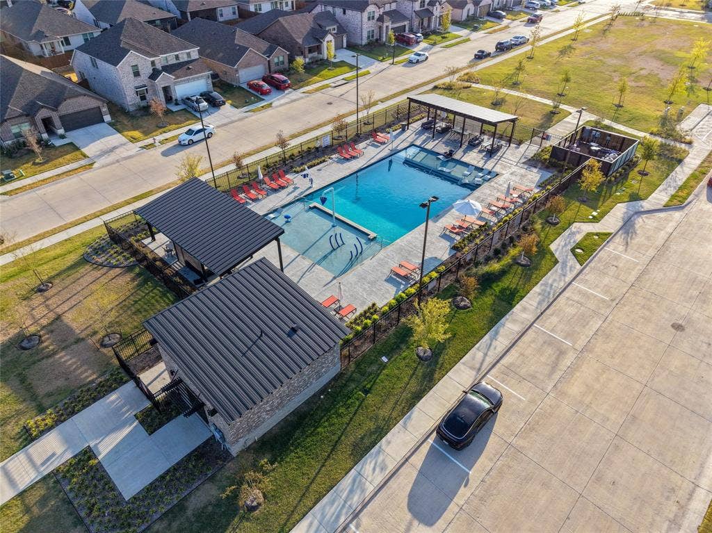 113 Greenbriar Drive, Princeton, TX 75071 Community swimming pool with surrounding concrete decking, two covered cabanas, and integrated lounge seating