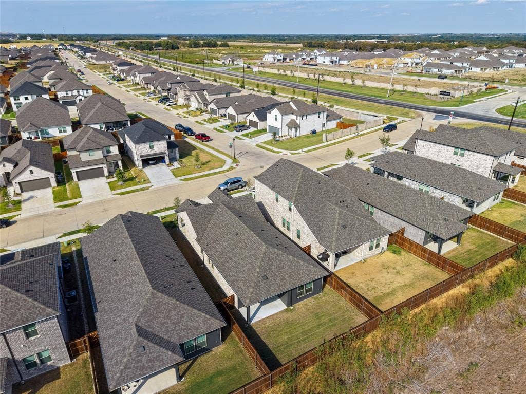 113 Greenbriar Drive, Princeton, TX 75071 Residential neighborhood street with multiple two-story homes, brick and siding exteriors, attached garages, and fenced backyards