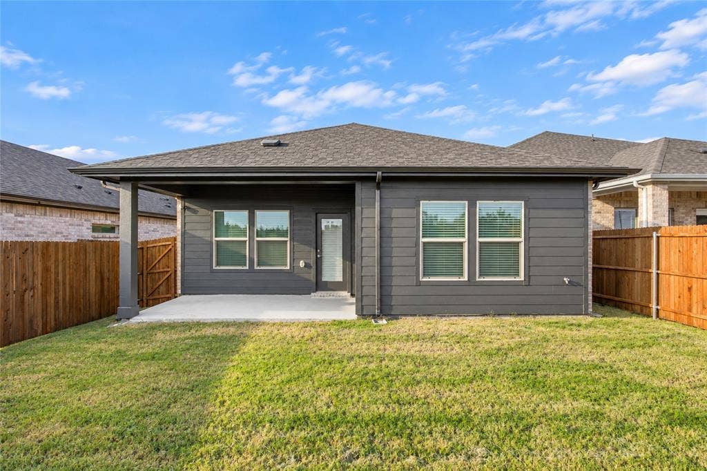 113 Greenbriar Drive, Princeton, TX 75071 Spacious backyard with a covered patio, dark gray siding, and a wooden privacy fence