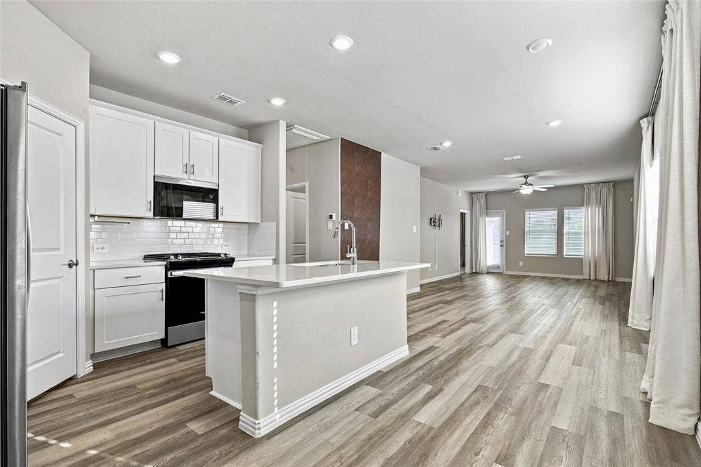 113 Greenbriar Drive, Princeton, TX 75071 Kitchen featuring white shaker cabinetry, subway tile backsplash, and a central island