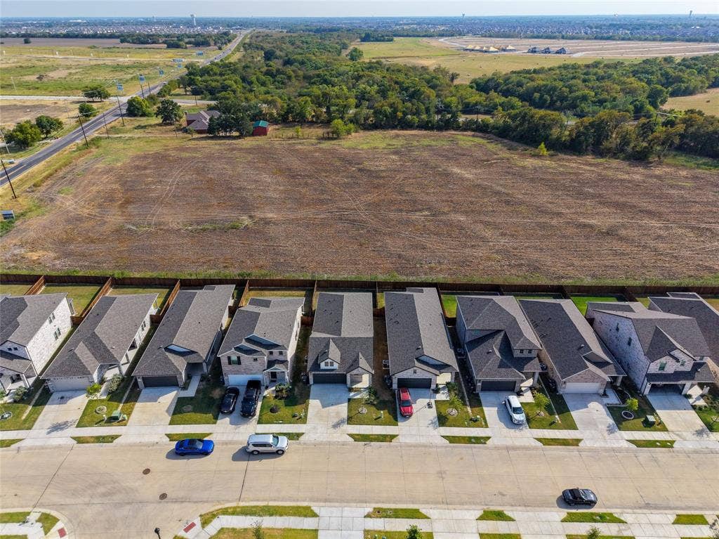 113 Greenbriar Drive, Princeton, TX 75071 Row of residential properties with varied architectural styles, asphalt shingle roofs, attached garages, and concrete driveways