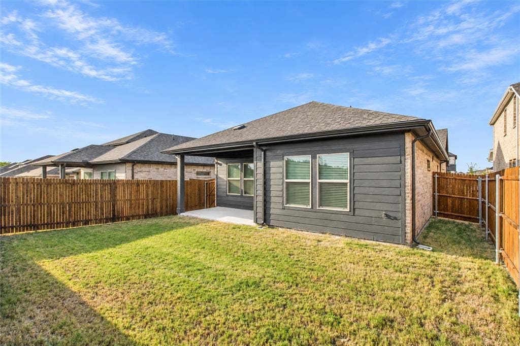 113 Greenbriar Drive, Princeton, TX 75071 Backyard featuring a covered patio, wood privacy fencing, and a manicured lawn