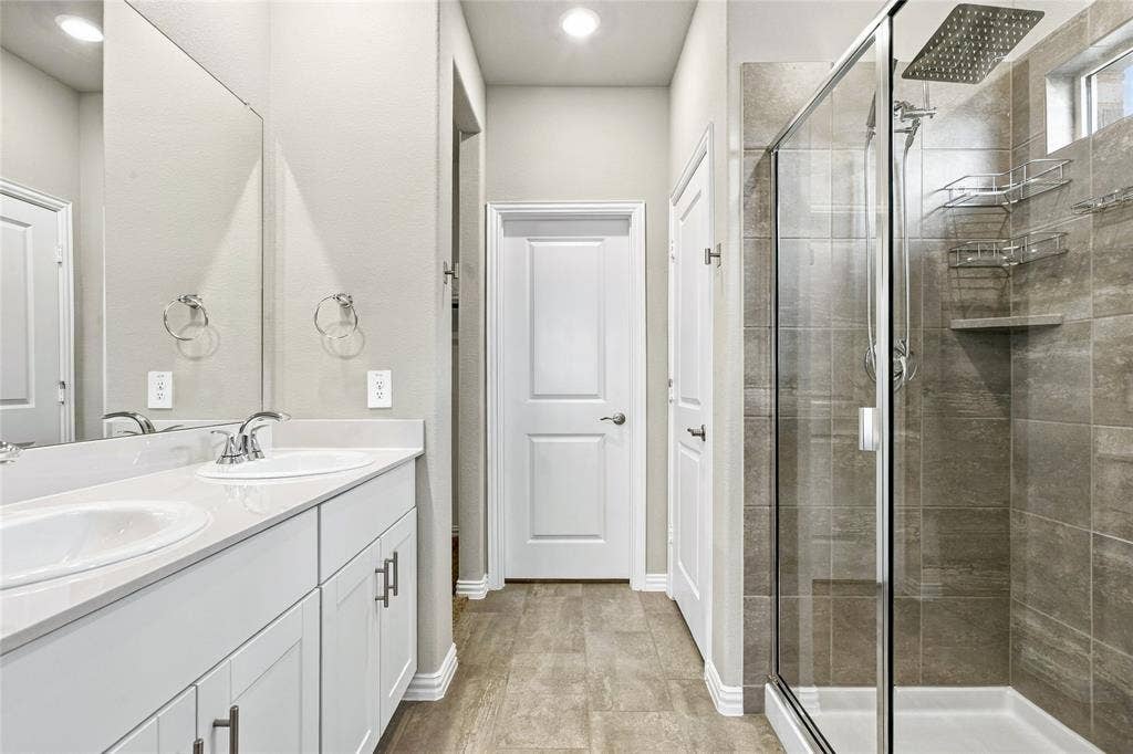 113 Greenbriar Drive, Princeton, TX 75071 Dual vanity with white cabinetry, quartz-finish countertop, and chrome fixtures