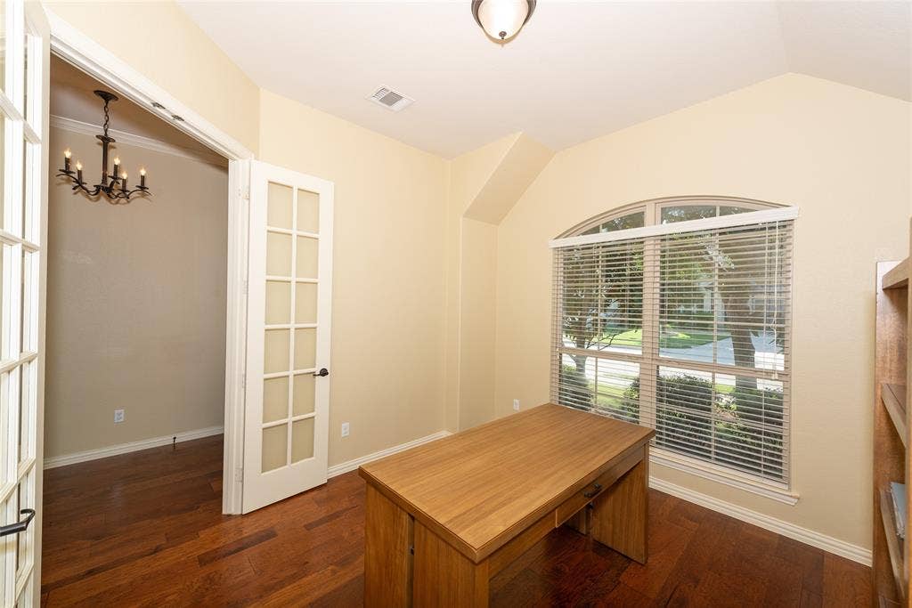 Wood-finish flooring throughout, French doors with glass panels, arched window, and recessed ceiling details
