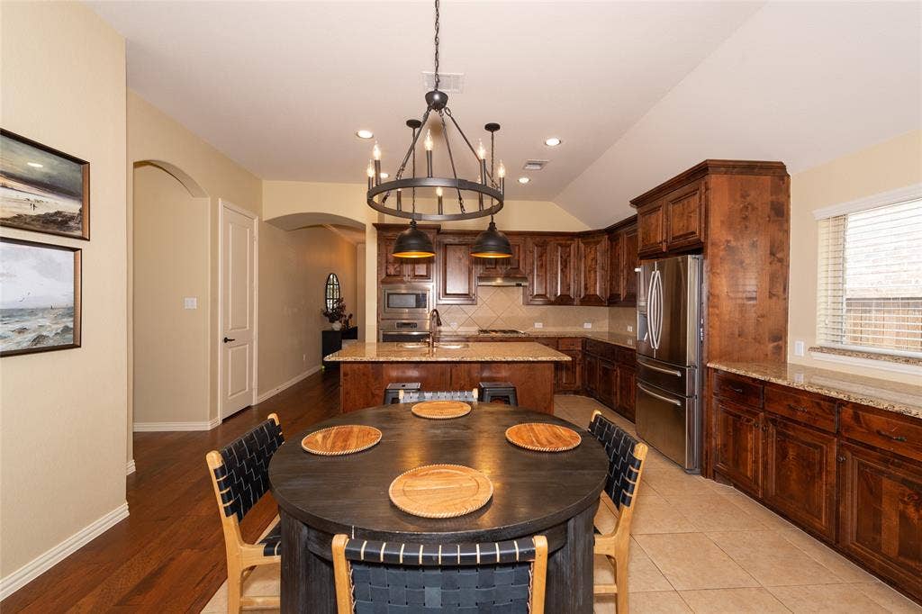 Spacious kitchen featuring rich wood cabinetry, stainless steel appliances, a large center island, and recessed lighting