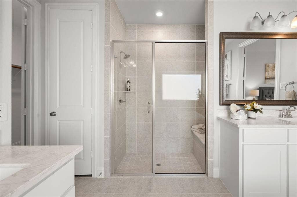 1320 Cartona Road, Fate, TX 75087 Tiled walk-in shower with glass enclosure, built-in bench, and shelving