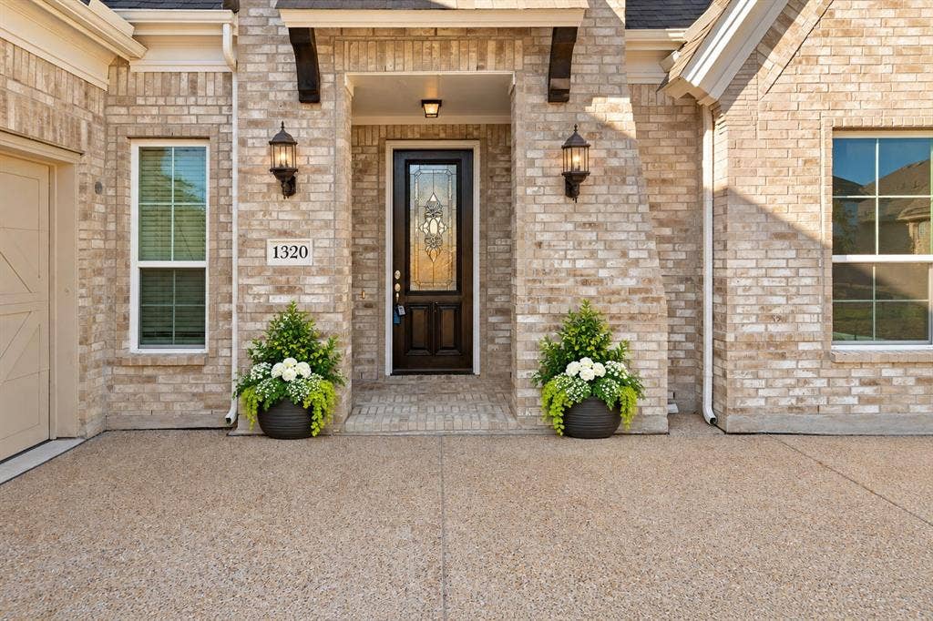 1320 Cartona Road, Fate, TX 75087 Brick exterior with exposed aggregate driveway and an ornate glass-paneled front door