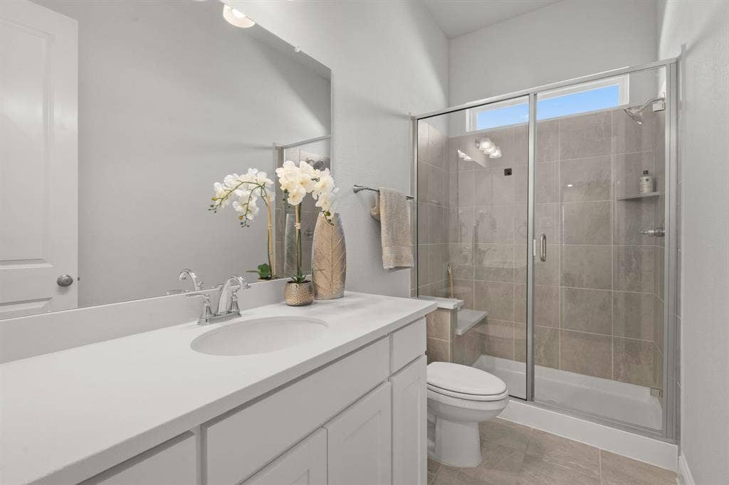 1320 Cartona Road, Fate, TX 75087 Walk-in shower with glass enclosure, built-in bench, and tiled walls
