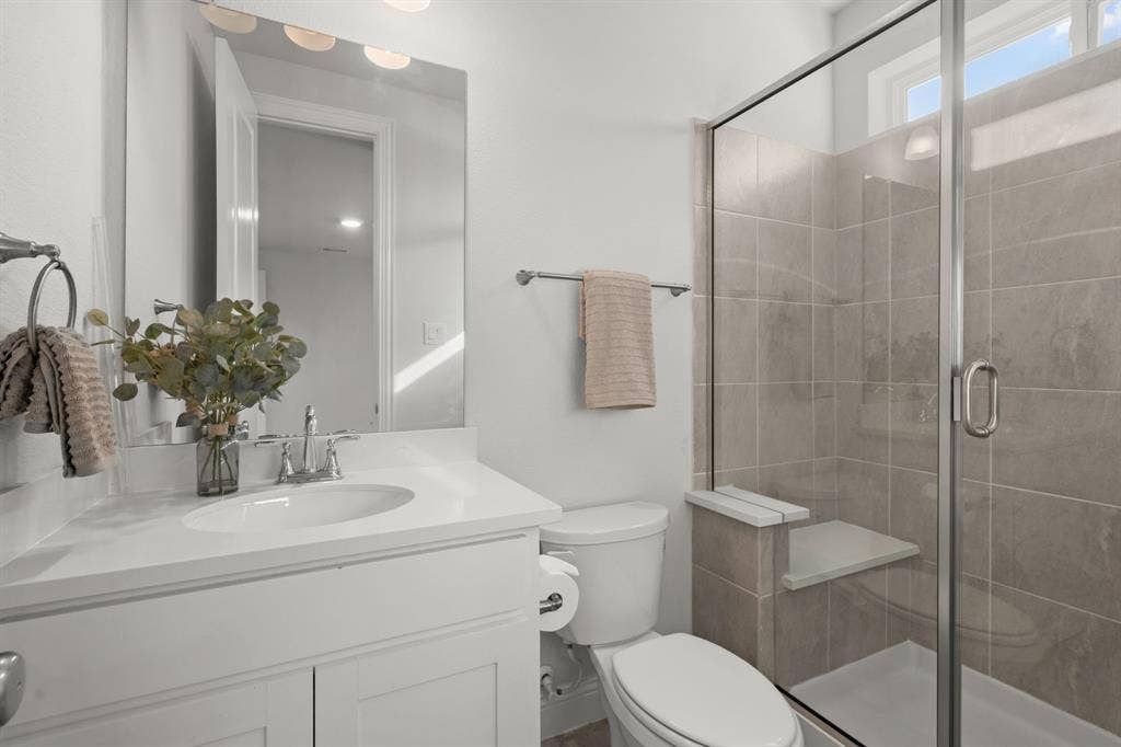 1320 Cartona Road, Fate, TX 75087 Vanity with an integrated sink, polished chrome faucet, and a large wall-mounted mirror
