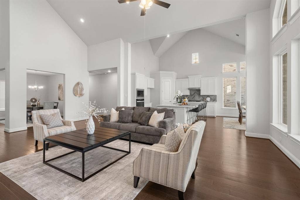 1320 Cartona Road, Fate, TX 75087 Soaring vaulted cathedral style ceilings, rich wood-finish flooring, abundant natural light, recessed lighting, and a kitchen featuring white cabinetry - Open Floor Plan