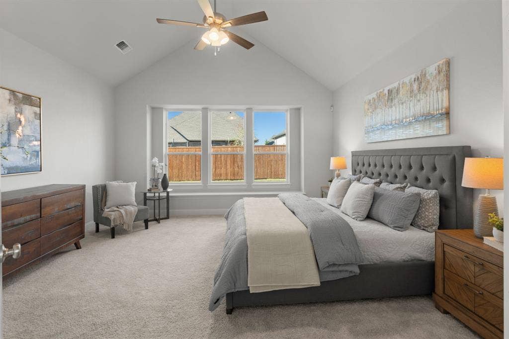 1320 Cartona Road, Fate, TX 75087 Vaulted ceiling with a ceiling fan, carpeted flooring, and a large bay window