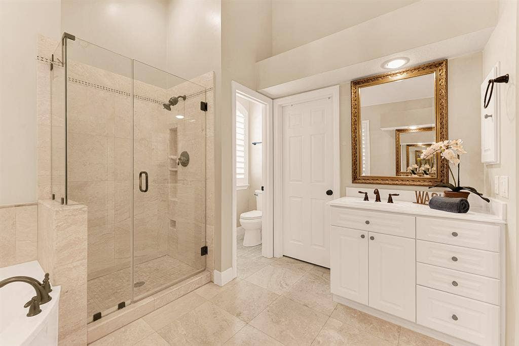 6429 GLENHOLLOW Drive, Plano, TX 75093 A frameless glass shower enclosure stands beside a soaking tub, accentuating clean lines and an airy atmosphere. Visualize washing away daily stress under a soothing stream of warm water